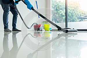 Young attractive man is cleaning vacuum commercial cleaning equipment on floor at home helping wife