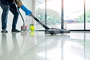 Young attractive man is cleaning vacuum commercial cleaning equipment on floor at home helping wife