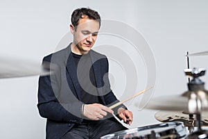 Young attractive man drummer playing drums and cymbals isolated on white background