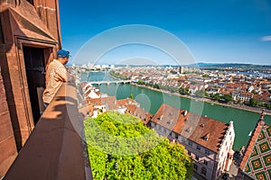 Young attractive man enjoying the view to old city center of Basel from Munster cathedral, Switzerland, Europe