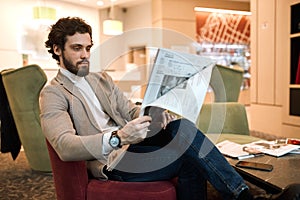 Young attractive man having a rest in the waiting room, waiting for a flight