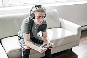 Young attractive man playing video games in the livingroom