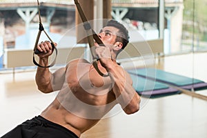 Young Attractive Man Training With Trx Fitness Straps