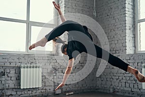 The young attractive modern ballet dancer in black jacket