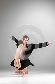 The young attractive modern ballet dancer on white