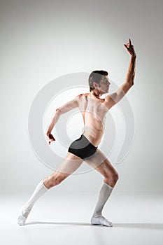The young attractive modern ballet dancer on white