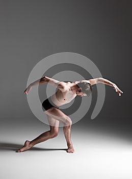 The young attractive modern ballet dancer on white