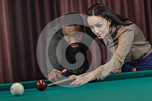 young attractive multiethnic man and woman playing in pool