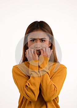 Young attractive nervous scared asian girl bitting her nails in studio