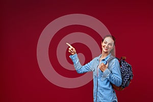 Young attractive positive female student with an open mouth with a backpack