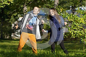 Young attractive pregnant woman in dress and happy man, dancing and smiling in park, 9 months pregnancy, expecting child