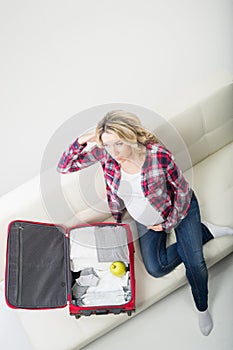 Young attractive pregnant woman packing children's wear