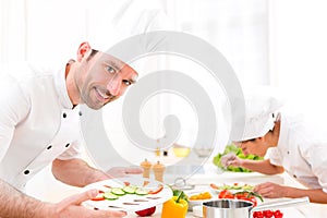 Young attractive professional chef cooking in his kitchen