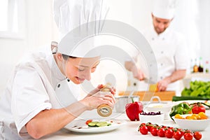 Young attractive professional chef cooking in his kitchen