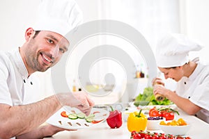 Young attractive professional chef cooking in his kitchen