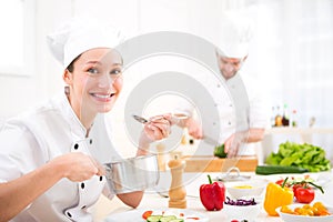 Young attractive professional chef cooking in his kitchen