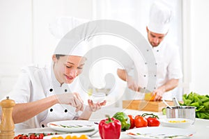 Young attractive professional chef cooking in his kitchen