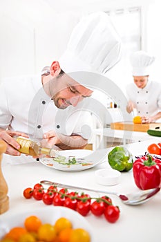 Young attractive professional chef cooking in his kitchen