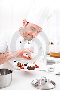 Young attractive professional chef cooking in his kitchen