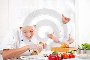 Young attractive professional chef cooking in his kitchen