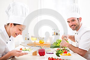 Young attractive professional chef cooking in his kitchen