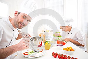 Young attractive professional chef cooking in his kitchen