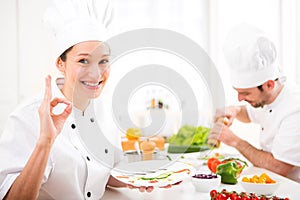 Young attractive professional chef cooking in his kitchen