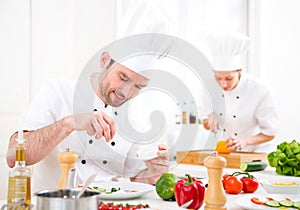 Young attractive professional chef cooking in his kitchen