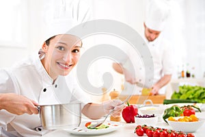 Young attractive professional chef cooking in his kitchen