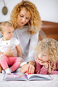 Young attractive red-haired woman enjoying spending time with her children