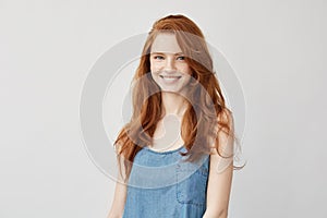 Young attractive redhead girl smiling looking at camera.