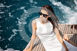Young, attractive and rich woman having fotossesion on a luxury boat in sea