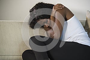 Young attractive and sad black African American woman sitting depressed at home sofa couch feeling anxious and frustrated sufferin