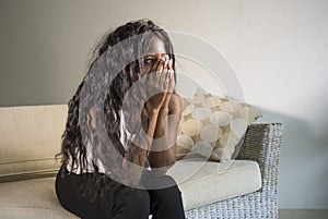 Young attractive and sad black African American woman sitting depressed at home sofa couch feeling anxious and frustrated sufferin