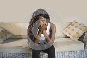 Young attractive and sad black African American woman sitting depressed at home sofa couch feeling anxious and frustrated sufferin
