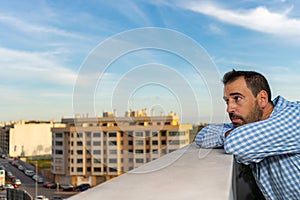 Young attractive, sad and desperate hispanic man suffering from depression who looks thoughtful and frustrated on the terrace of