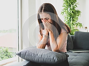 Young attractive and sad woman sitting depressed at home sofa couch feeling anxious and frustrated suffering depression problem,