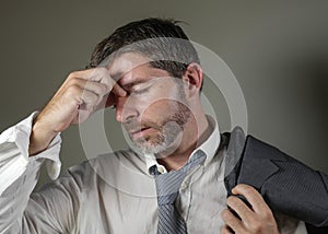 Young attractive sad and worried businessman in lose tie and messy look feeling depressed and stressed in overwhelmed face