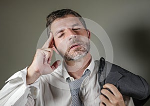 Young attractive sad and worried businessman in lose tie and messy look feeling depressed and stressed in overwhelmed face