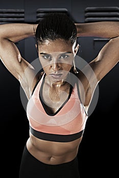 Young attractive latin sport woman posing in fierce and badass face expression with fit slim body