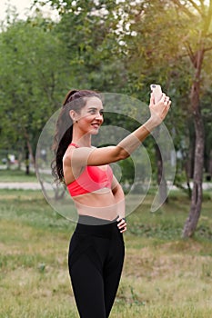 Young attractive smiling toned brunette woman doing selfie while working out Healthy lifestyle concept