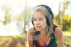 Young attractive sportswoman listening to music wearing headphones. Sport, fitness, workout