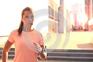 Young attractive sporty fitness woman running while exercising outdoors at sunset or sunrise in city.