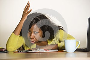 Young attractive stressed and overworked black African American woman working upset and desperate at office computer desk feeling
