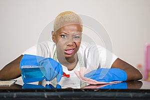 Young attractive stressed and upset back afro American woman in washing rubber gloves cleaning home kitchen tired and overworked i