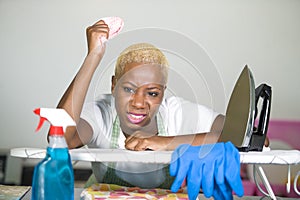 Young attractive stressed and upset back afro American woman in washing rubber gloves cleaning home kitchen tired and overworked i