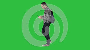 Young attractive student backpacker tourist taking selfie photo with mobile phone on a Green Screen, Chroma Key.