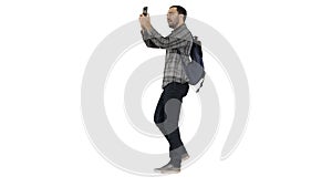 Young attractive student backpacker tourist taking selfie photo with mobile phone on white background.