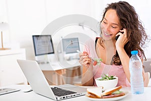 Young attractive student eating salad while phoning