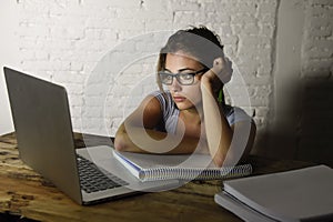 Young attractive student girl or working woman sitting at computer desk in stress looking tired exhausted and boring